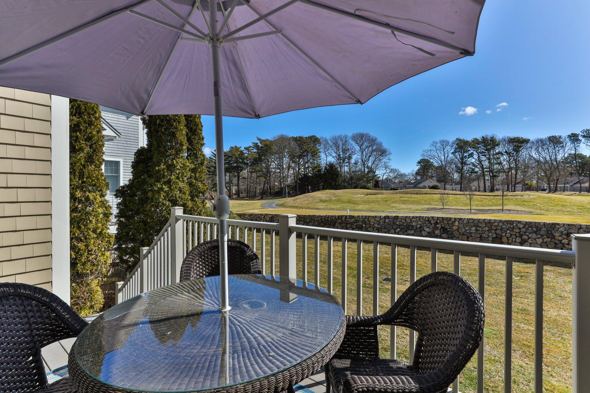 16 Quinns Way Mashpee, MA 02649 - Photo 34 of 59 a balcony with table and chairs under an umbrella