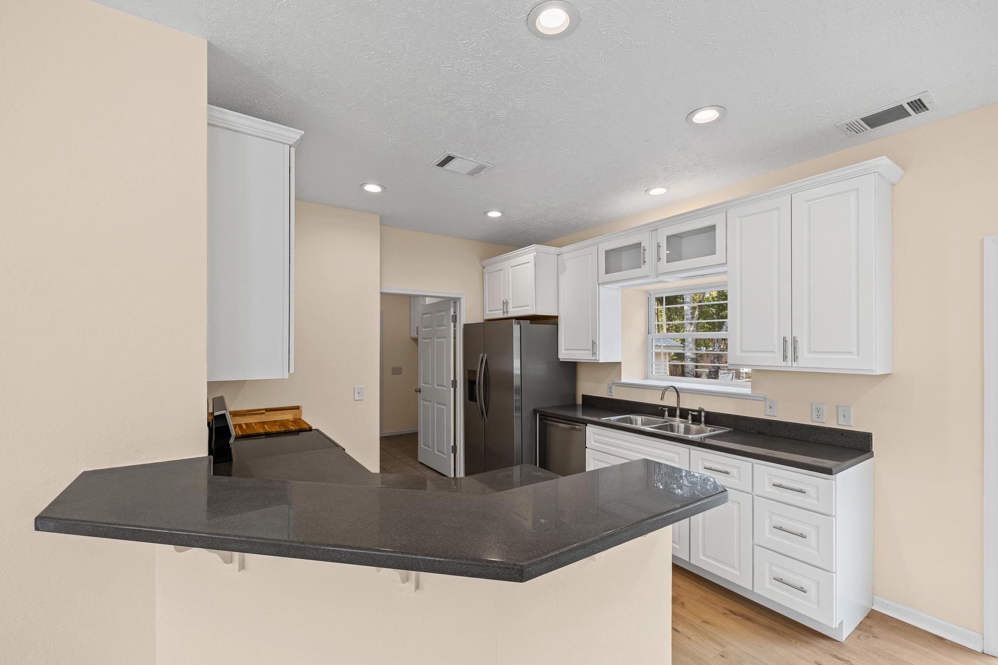 3159 Forrest Avenue Crestview, FL 32539 - Photo 15 of 41 a kitchen with kitchen island a counter top space cabinets and stainless steel appliances