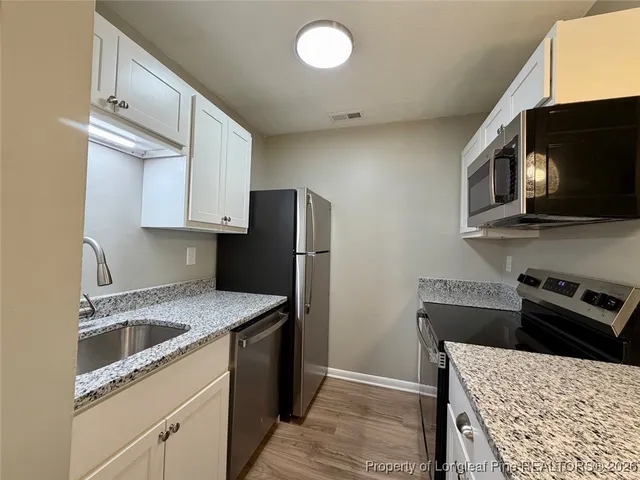 a kitchen with stainless steel appliances granite countertop cabinets stove and microwave