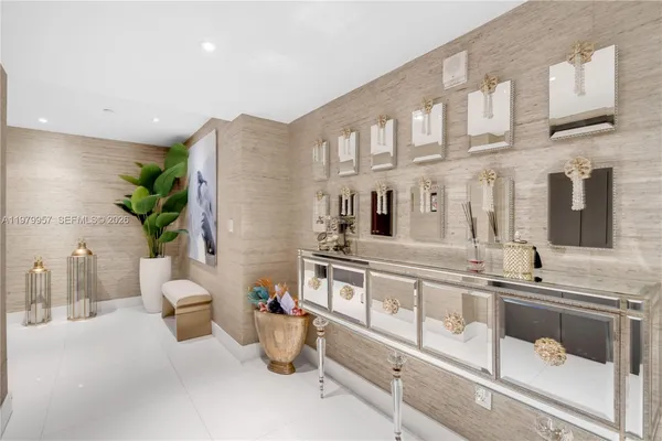 a large white kitchen with a sink and a large mirror