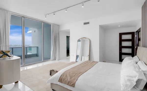 a bedroom with a bed and a large mirror