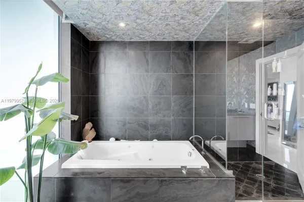 a bathroom with a tub sink and granite