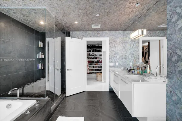 a bathroom with a double vanity sink a toilet and shower
