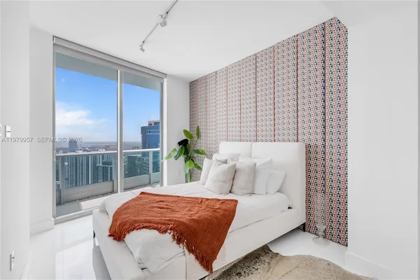 a bed sitting in a bedroom next to a window