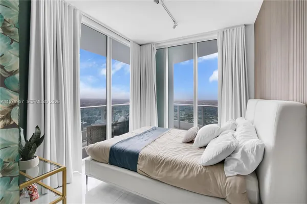 a bedroom with a large bed and a potted plant