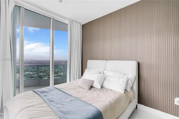 a large bed sitting in a bedroom next to a balcony