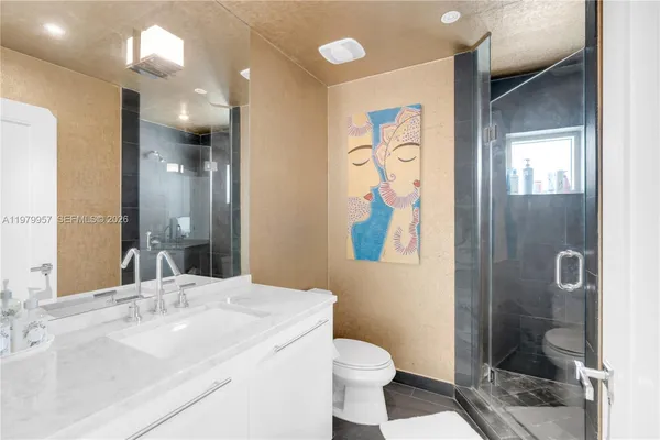 a bathroom with a sink a toilet and shower