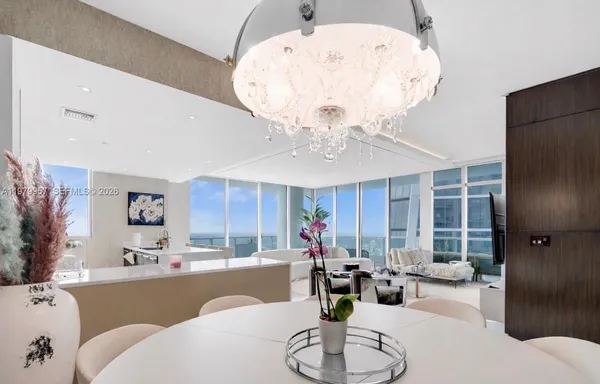 a living room with furniture chandelier and a dining table