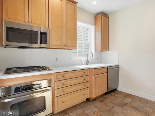 a kitchen with granite countertop cabinets stainless steel appliances and a sink