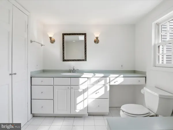 a bathroom with a sink a toilet and mirror