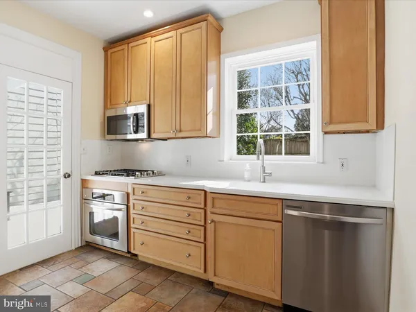 a kitchen with cabinets appliances and a window