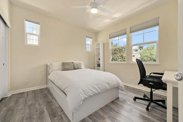 a bedroom with a bed a lamps and a large window