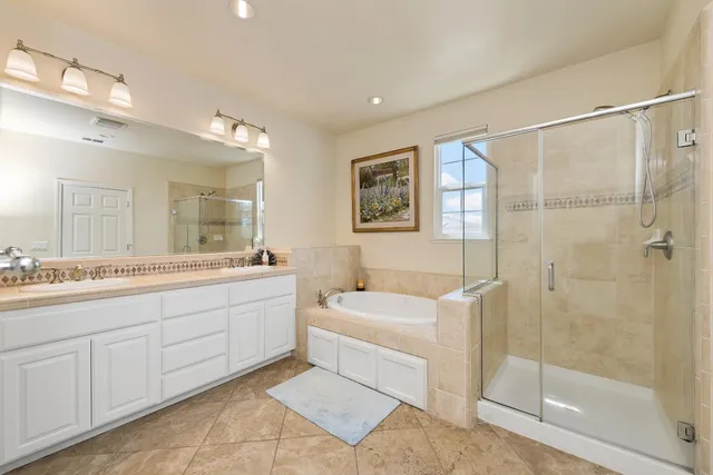 a bathroom with a tub sink and mirror