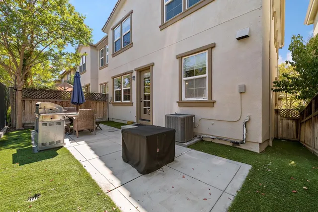 a backyard of a house with barbeque oven and outdoor seating