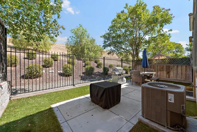 a view of a backyard with couches plants and wooden fence