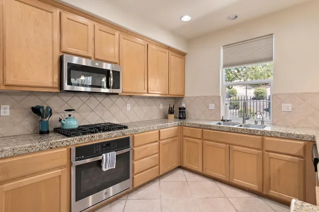 a kitchen with granite countertop cabinets stainless steel appliances and a sink