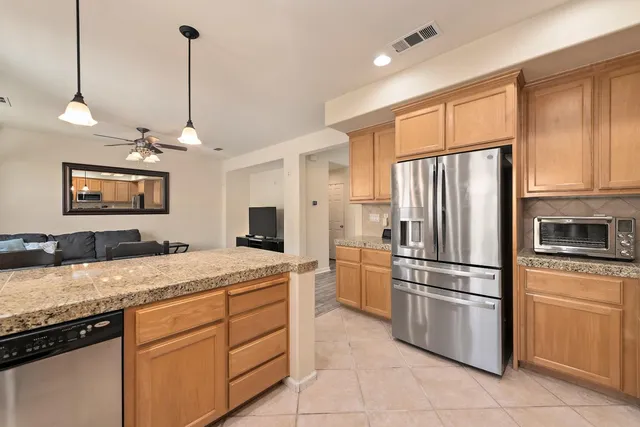 a kitchen with kitchen island granite countertop cabinets and refrigerator
