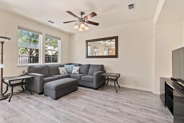 a living room with furniture a flat screen tv and a window
