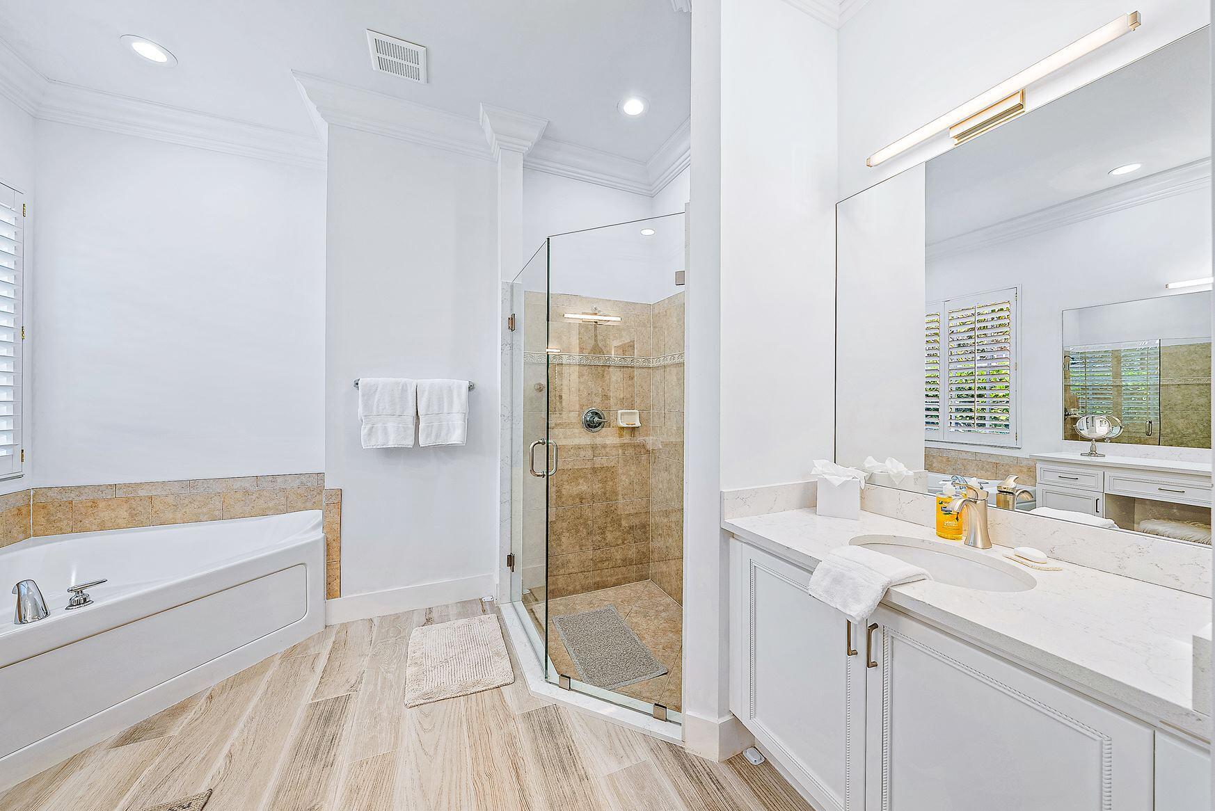 102 Via Santa Cruz Jupiter, FL 33458 - Photo 19 of 30 a bathroom with a tub sink and mirror
