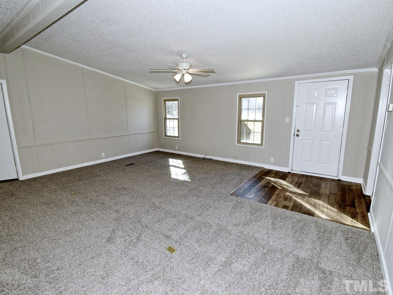 810 Dink Ashley Road Timberlake, NC 27583 - Photo 3 of 31 an empty room with chandelier fan and windows