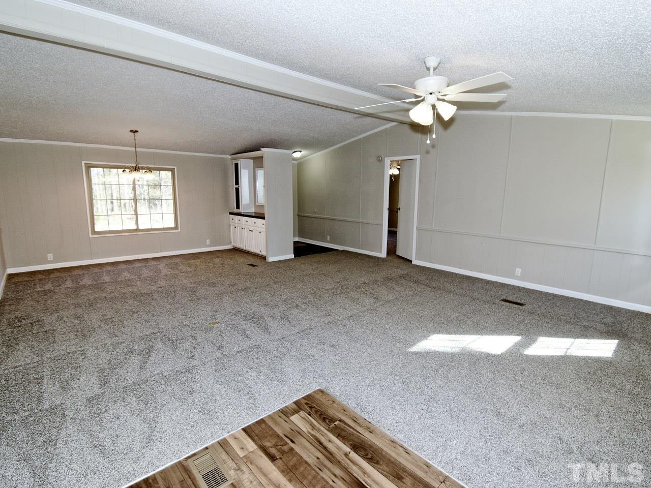 810 Dink Ashley Road Timberlake, NC 27583 - Photo 4 of 31 an empty room with windows and fan