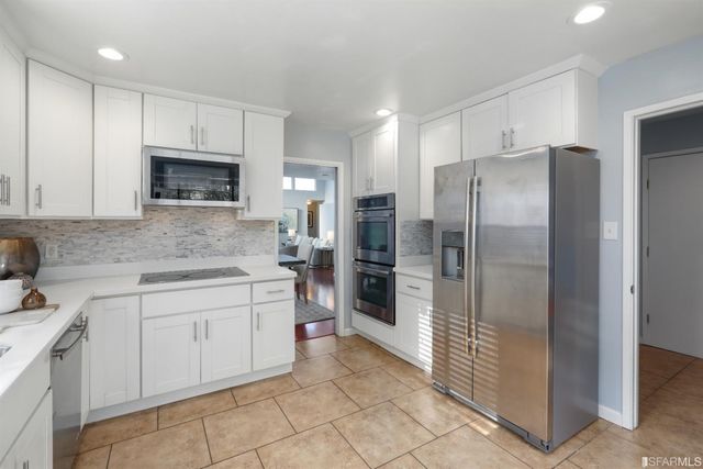 a kitchen with a refrigerator sink and cabinets