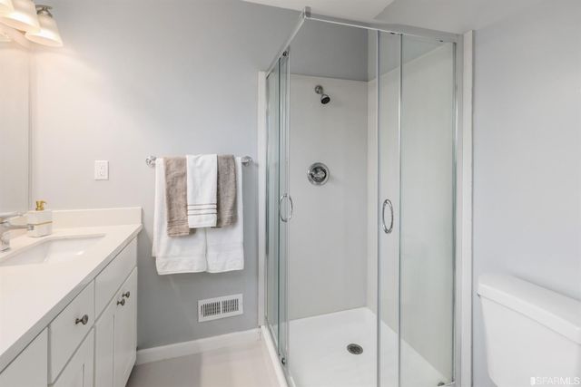 a bedroom with a bed and a lamp on dresser