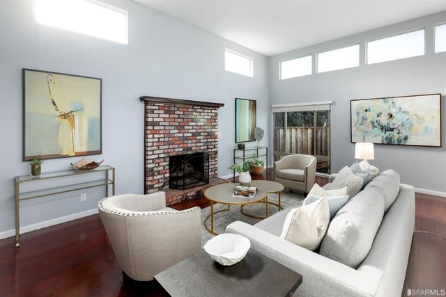 a living room with furniture a fireplace and a large window