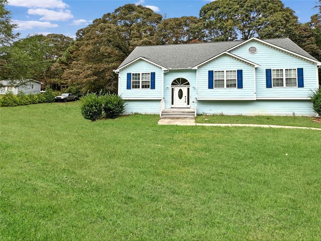 a front view of a house with a garden and yard