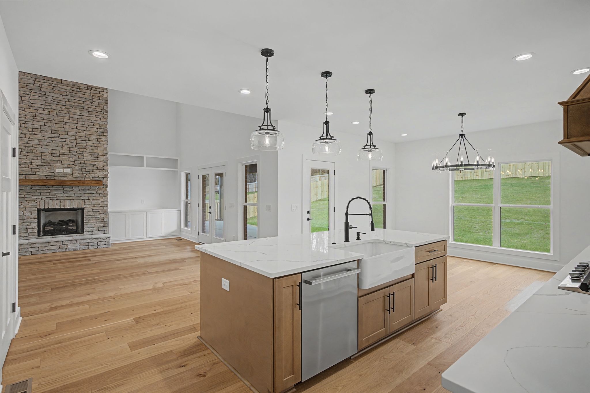 1491 Nonaville Road Mount Juliet, TN 37122 - Photo 23 of 60 a large white kitchen with a large island oven a sink dishwasher and a fireplace with wooden floor