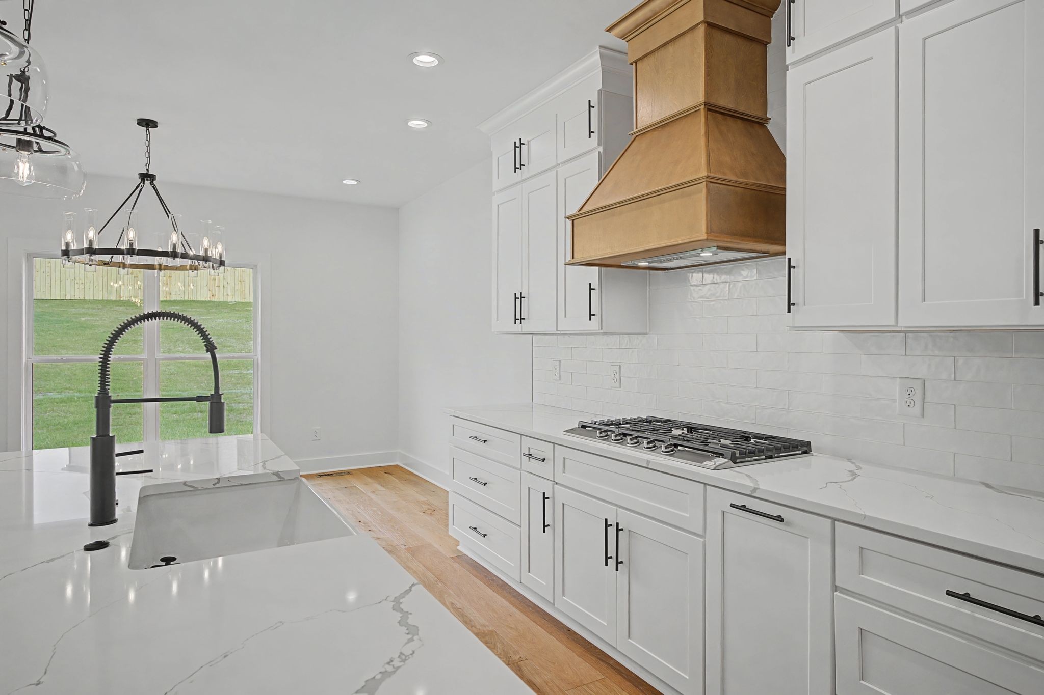 1491 Nonaville Road Mount Juliet, TN 37122 - Photo 24 of 60 a kitchen with white cabinets a sink a stove and a wooden floors