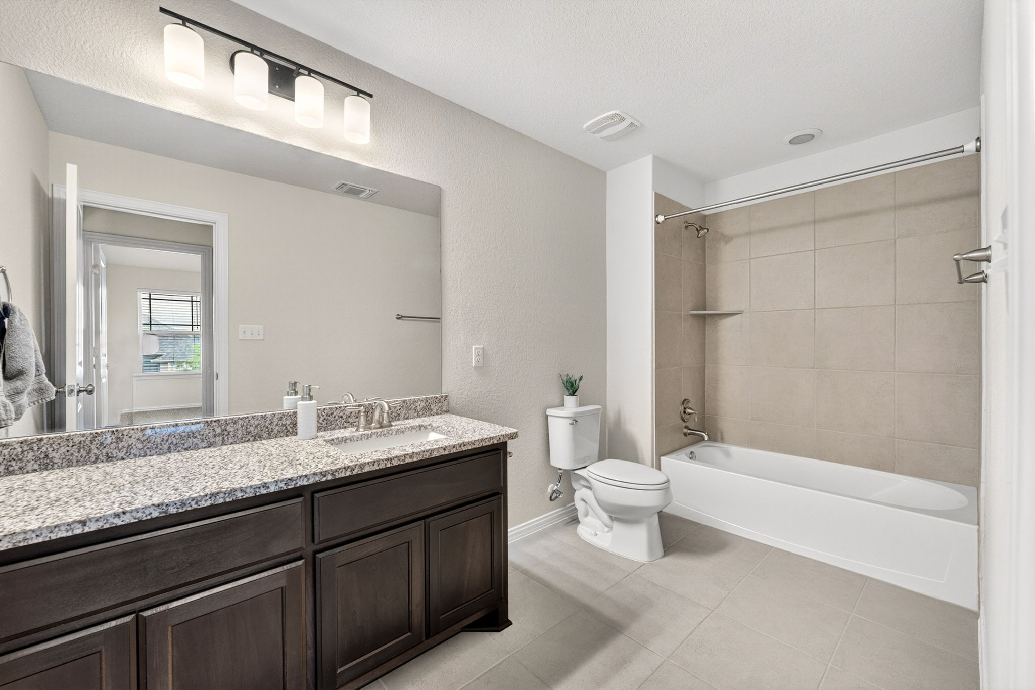 12613 Twisted Root Drive Manchaca, TX 78652 - Photo 21 of 32 a bathroom with a granite countertop sink a toilet a mirror and bathtub