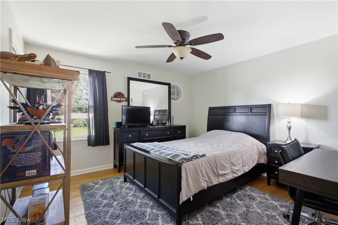 2411 Ridgeview Lane Youngstown, OH 44514 - Photo 20 of 48 Bedroom featuring wood-finish flooring, a ceiling fan with integrated lighting, and a single window with dark drapery