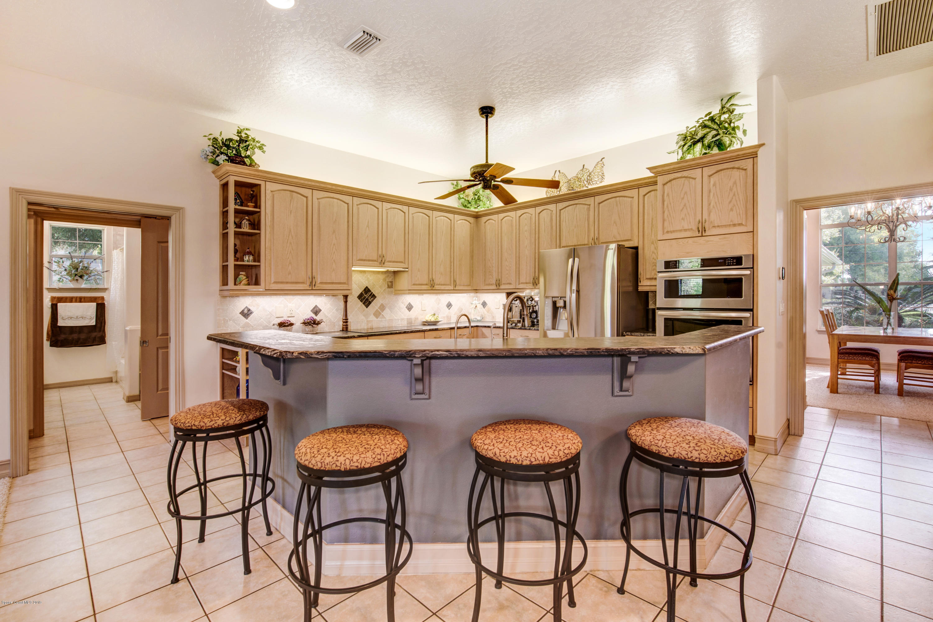 3570 Shady Run Road Melbourne, FL 32934 - Photo 11 of 39 a very nice looking dining room with kitchen island granite countertop a table and chairs with wooden floor