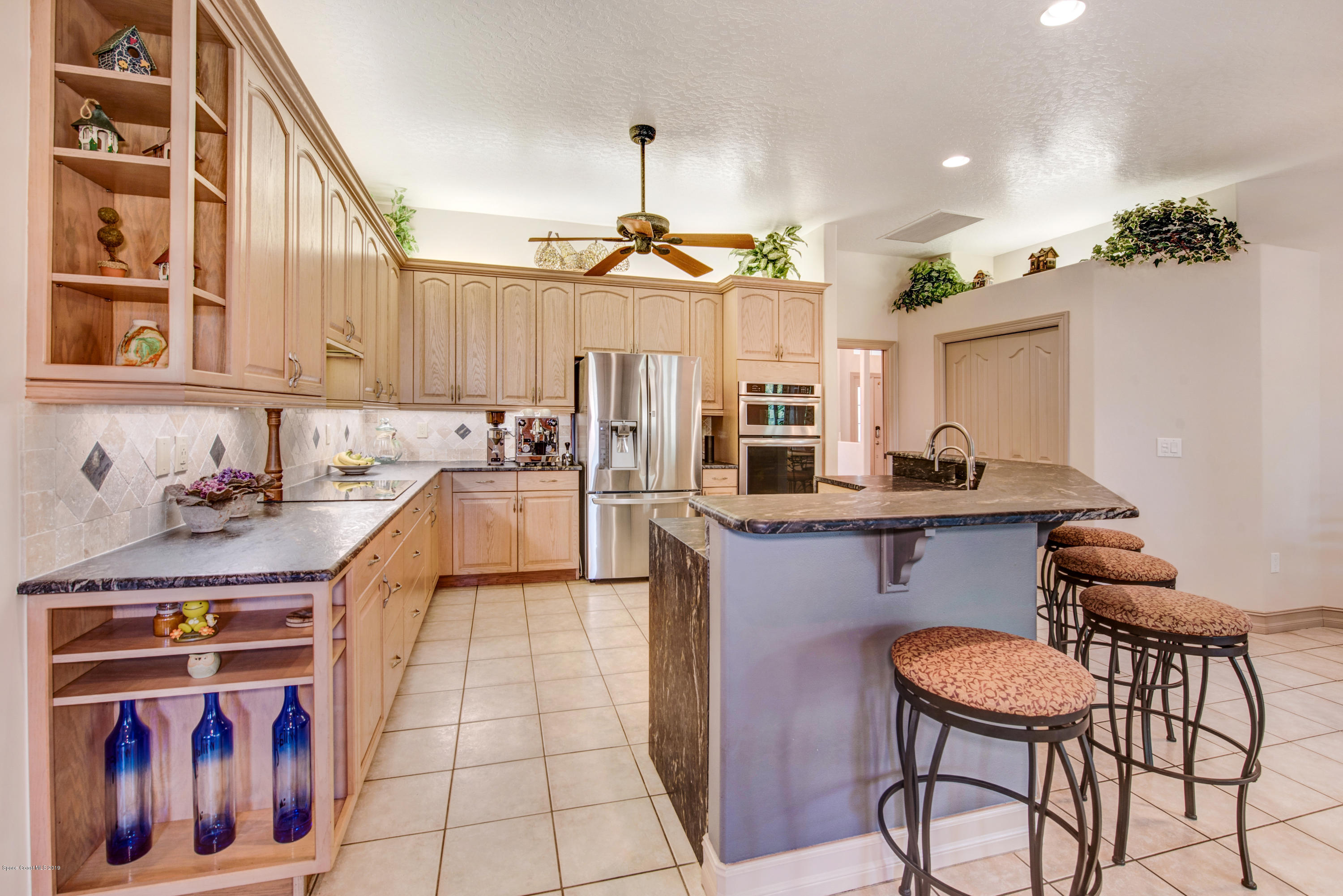 3570 Shady Run Road Melbourne, FL 32934 - Photo 12 of 39 a kitchen with stainless steel appliances granite countertop a stove a sink and a refrigerator