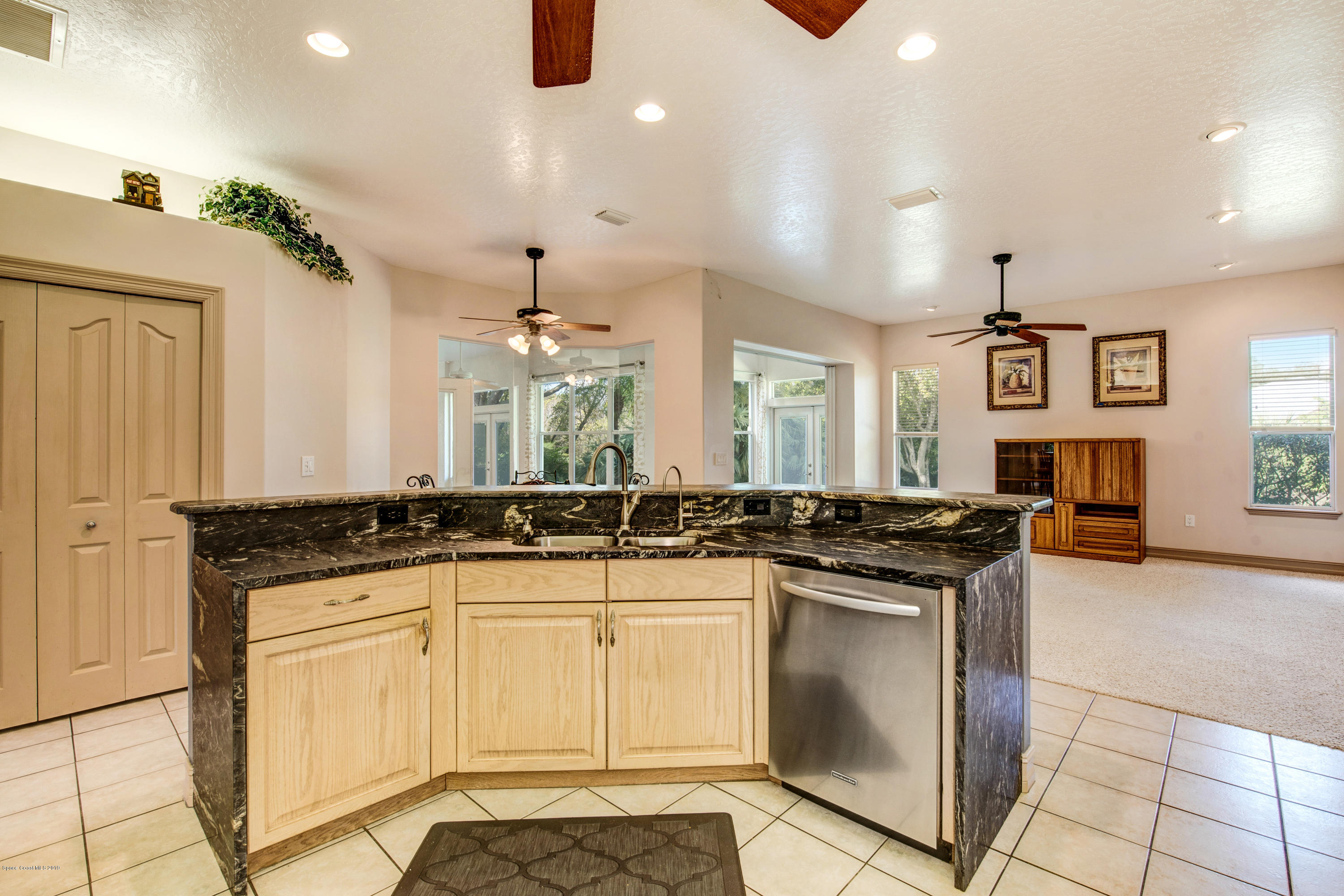 3570 Shady Run Road Melbourne, FL 32934 - Photo 13 of 39 a kitchen with granite countertop a sink and white cabinets
