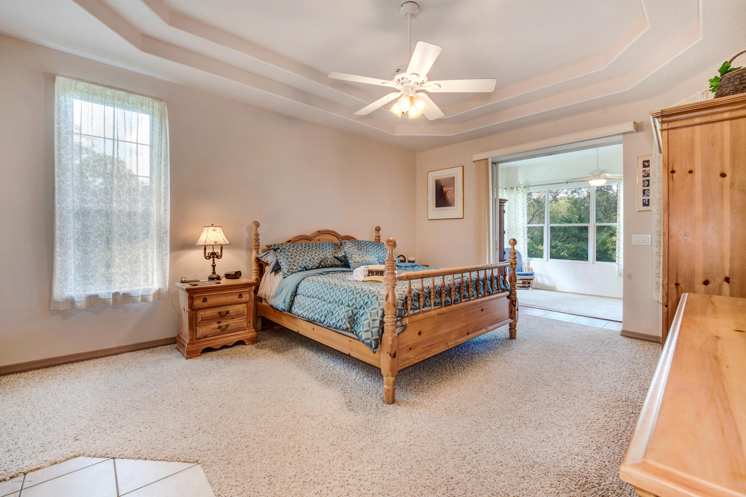 3570 Shady Run Road Melbourne, FL 32934 - Photo 20 of 39 a bedroom with a bed and a chandelier