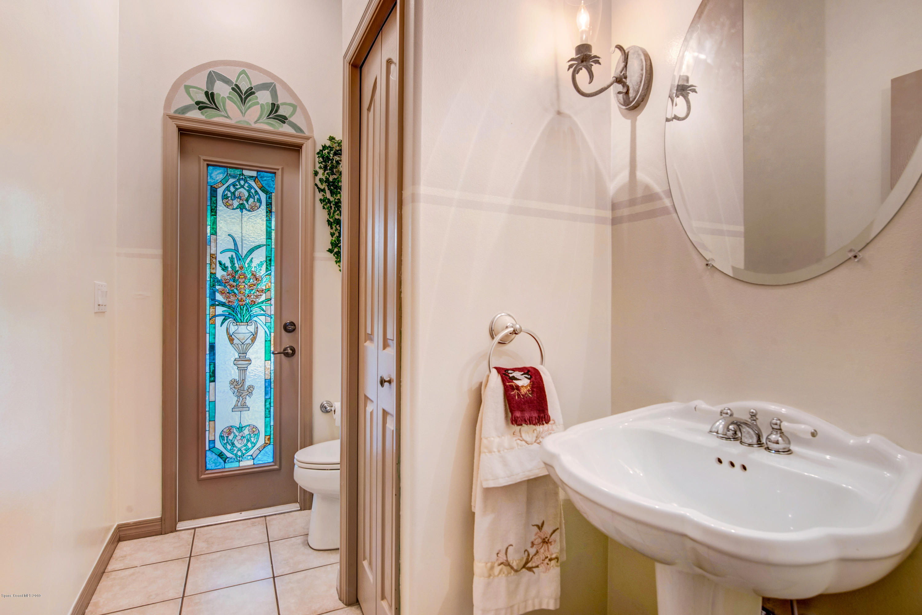 3570 Shady Run Road Melbourne, FL 32934 - Photo 24 of 39 a bathroom with a sink a mirror and a window
