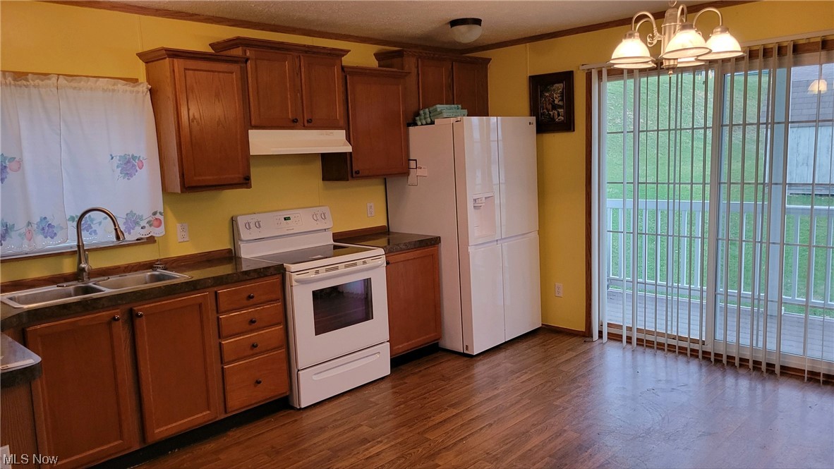 85 Rains Circle Zanesville, OH 43701 - Photo 4 of 15 Kitchen with a notable chandelier, dark hardwood / wood-style floors, white appliances, sink, and hanging light fixtures