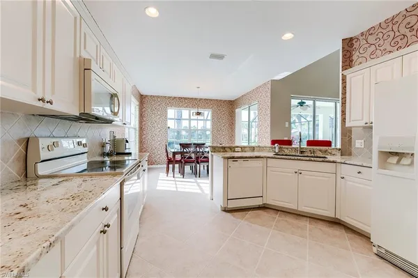 a kitchen with granite countertop refrigerator and cabinets