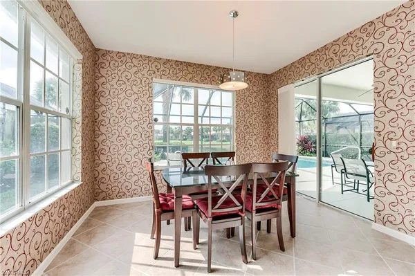 a dining room with furniture and large windows