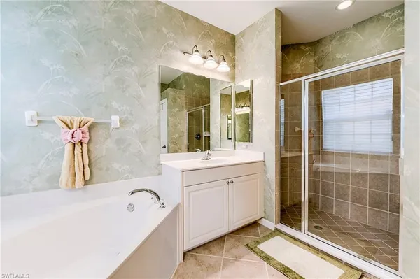 a bathroom with a tub sink and mirror