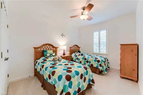 a bedroom with two beds and a chandelier