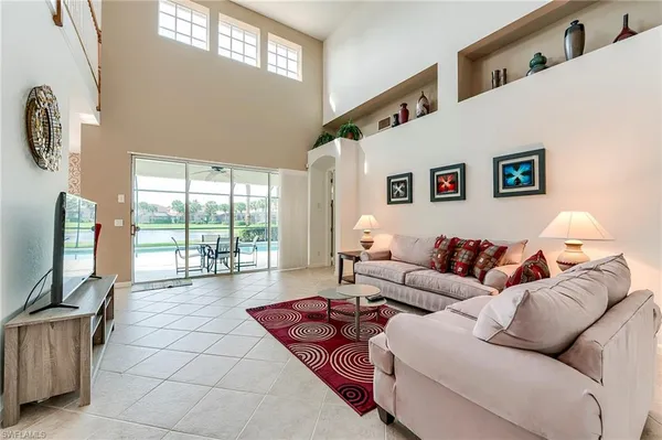 a living room with furniture a flat screen tv and a large window