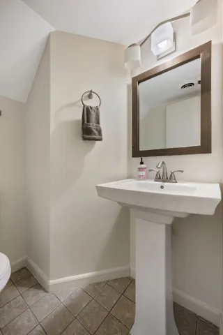 a bathroom with a sink a toilet and mirror