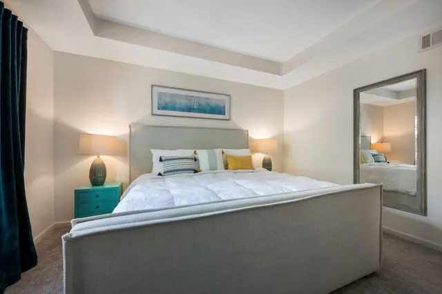 a bedroom with a bed and a painting on the wall