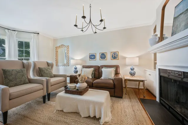 a living room with furniture a fireplace and a chandelier