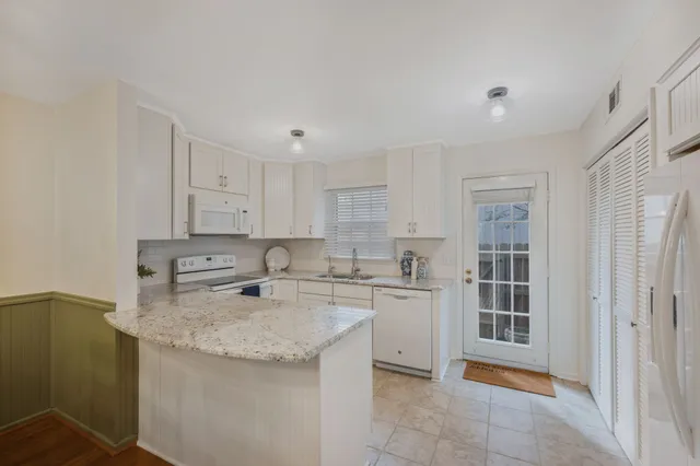 a kitchen with stainless steel appliances granite countertop a sink stove and cabinets