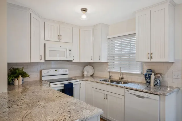 a kitchen with stainless steel appliances granite countertop a sink a stove and cabinets