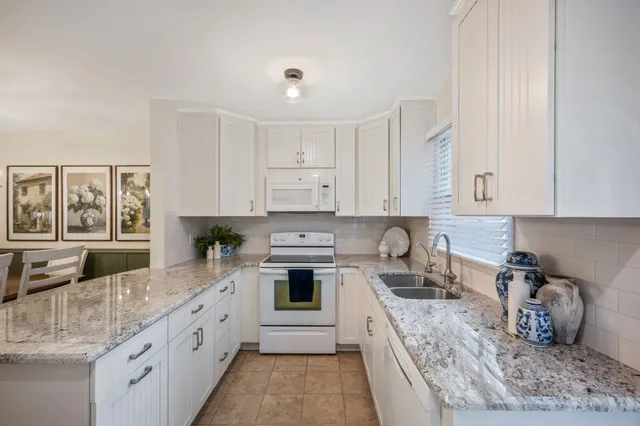 a kitchen with granite countertop a sink stove and cabinets
